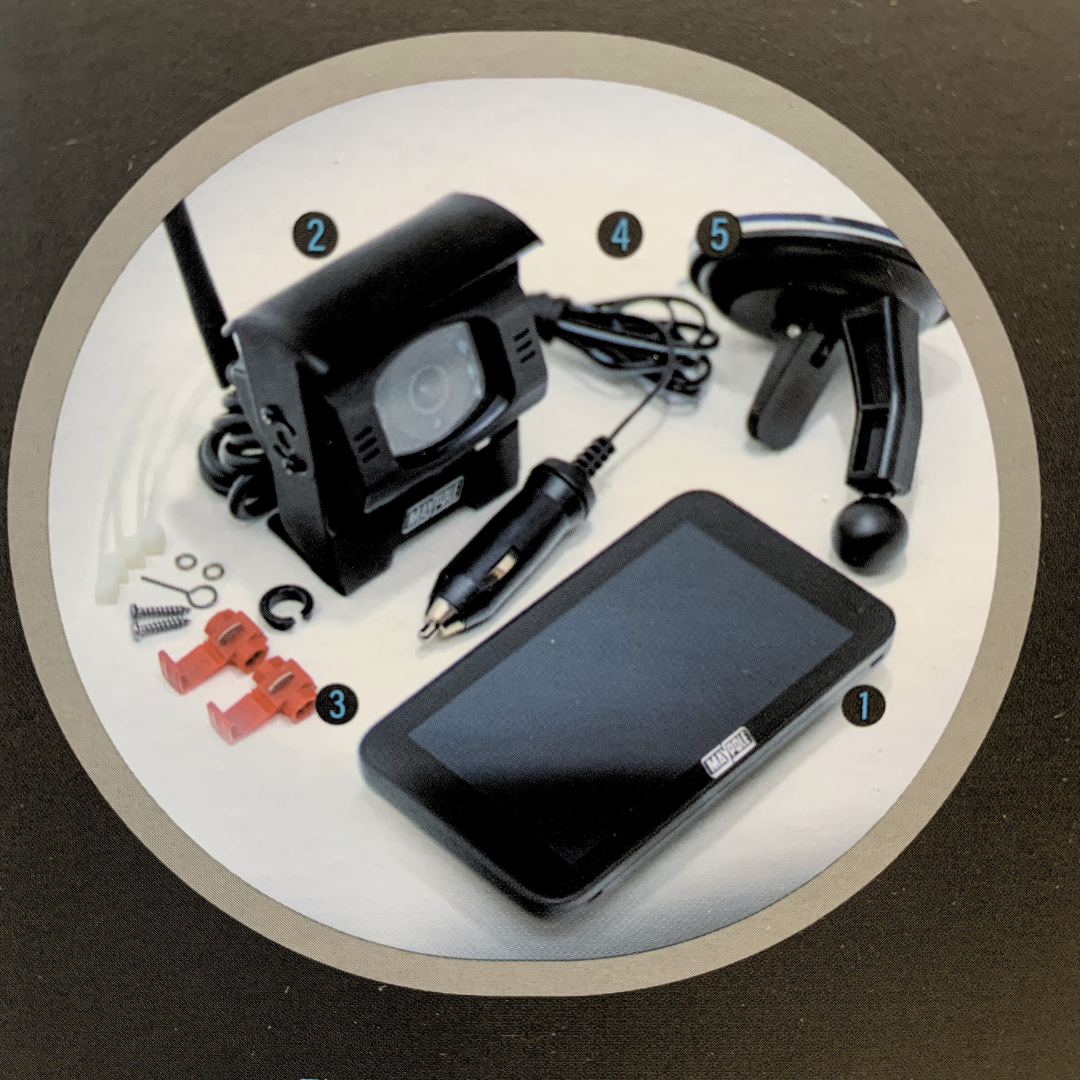 Collection of car accessories including a camera, power adapter, and phone on a white circular mat.